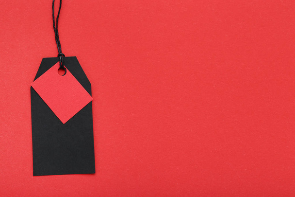 Black and red sale tag on red background - Φωτογραφία, εικόνα