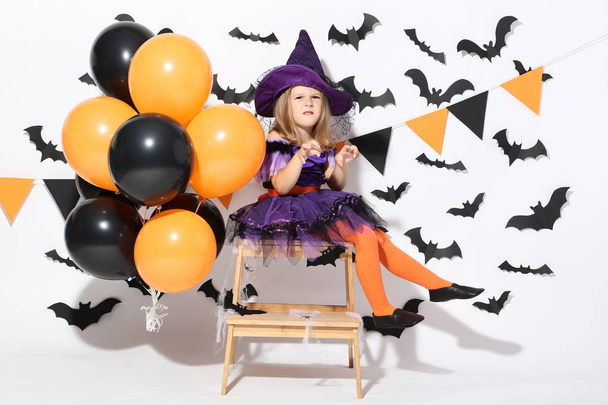 Young girl in halloween costume with balloons on white background - Foto, Bild