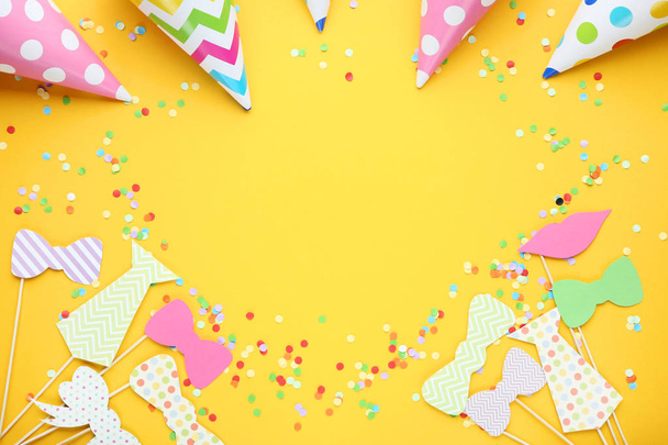 Colorful booth props for party with paper caps on yellow background - 写真・画像