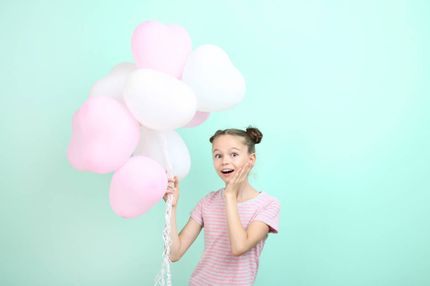 Beautiful young girl with balloons on mint background - Фото, изображение