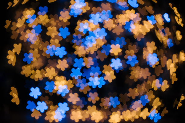 full frame of shiny blue and golden stars bokeh lights on black backdrop - Foto, imagen