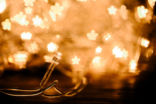 close up view of festive garland and stars bokeh lights backdrop - 写真・画像