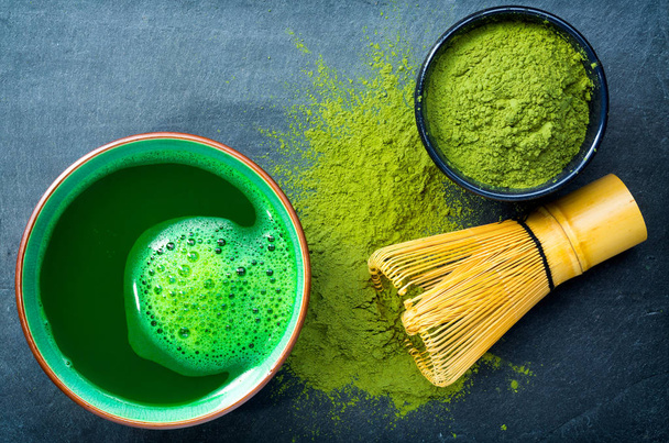 Cup of matcha green tea with matcha ground, bamboo, whisk, spoon - 写真・画像