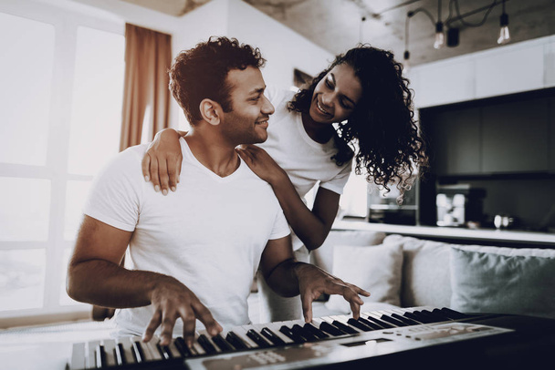 Girl Is Hanging A Boyfriend Playing Synthesizer. Happy Songwriter. Morning Leisure. Digital Format. Working Musician. Musical Hobby. Hands On Keyboard. Afro American Couple. Take A Rhytm. - Foto, imagen