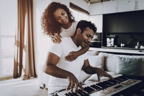 Girl Is Hanging A Boyfriend Playing Synthesizer. Happy Songwriter. Morning Leisure. Digital Format. Working Musician. Musical Hobby. Hands On Keyboard. Afro American Couple. Take A Rhytm. - Foto, immagini