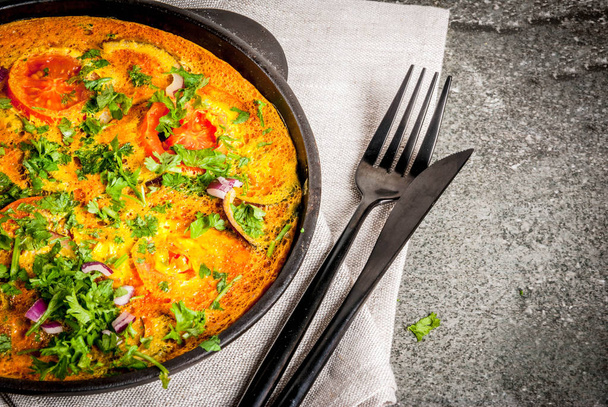 Indian food recipes, Masala Omelette with fresh vegetables - tomato, hot chili pepper, parsley, dark stone background, copy space - Photo, Image