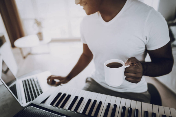 Young Man Is Recording A Song With Cup Of Coffee. Happy Songwriter. Morning Leisure. Digital Format Sound Record. Working Musician. Musical Hobby. Hands On Keyboard. Working With Laptop. - 写真・画像