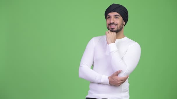 Studio shot of young handsome bearded Indian man wearing turban against chroma key with green background - Footage, Video