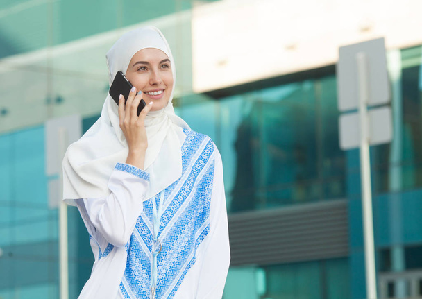 Portrait of a modern arabian girl using mobile phone on the street. - Foto, Imagem
