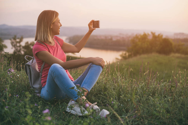 Красивая женщина любит фотографироваться с телефоном городского пейзажа и реки view.Image намеренно тонизируется
. - Фото, изображение