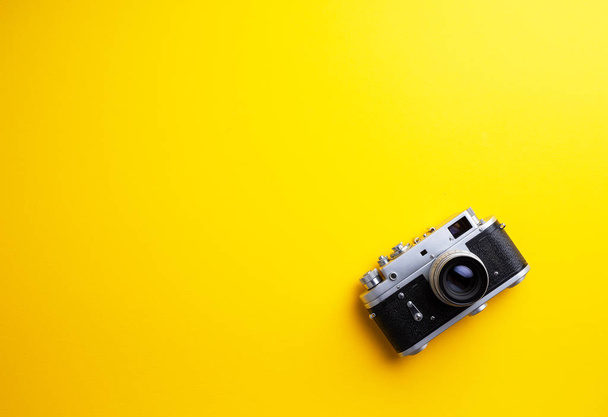 Oldtimer-Kamera über gelbem Hintergrund mit negativem Leerzeichen - Foto, Bild