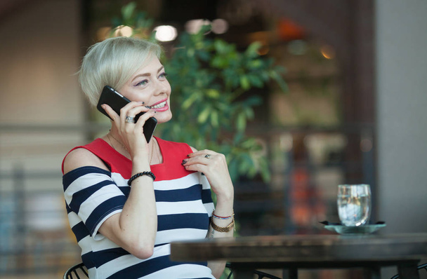 Beautiful and happy middle aged woman talking on mobile phone - 写真・画像