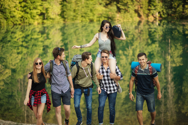 cheerful travelers are listening to the music while going hiking - Фото, изображение