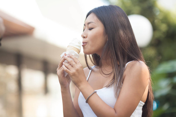 Photos of asian woman eating ice cream and stand in hot weather. The emotional happiness. Focus on face. - Fotó, kép