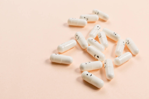 Capsules with painted emotions on a solid background. - Photo, Image