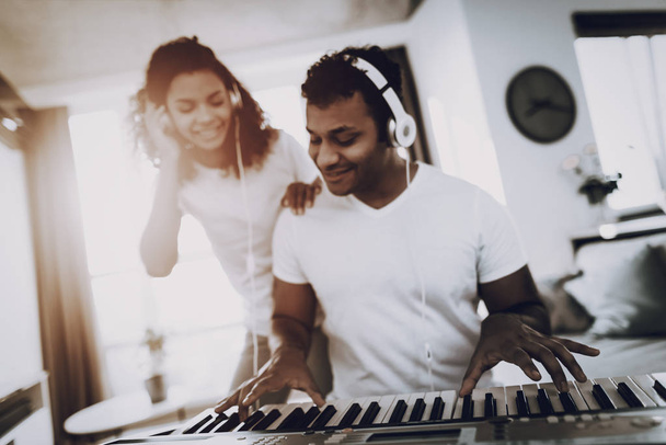 Afro American Couple Listening With Headphones Synthesizer Playing. Happy Songwriter. Morning Leisure. Digital Format Sound Record. Working Musician. Musical Hobby. Hands On Keyboard. - Foto, Imagem