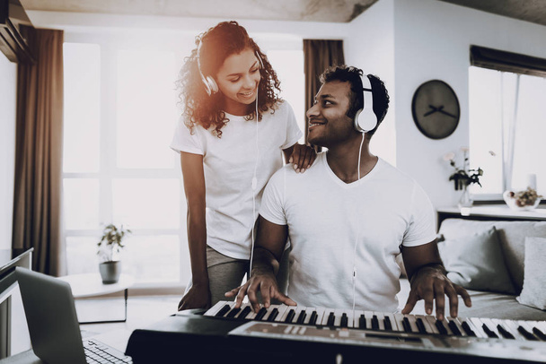 Afro American Couple Listening With Headphones Synthesizer Playing. Happy Songwriter. Morning Leisure. Digital Format Sound Record. Working Musician. Musical Hobby. Hands On Keyboard. - 写真・画像