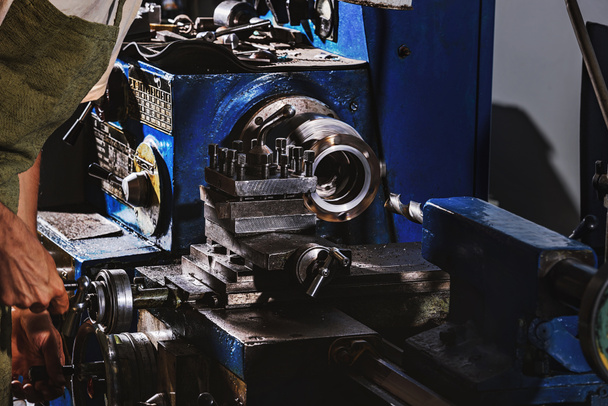 imagen recortada del trabajador masculino de la fabricación en delantal protector usando la máquina herramienta en fábrica
 - Foto, Imagen