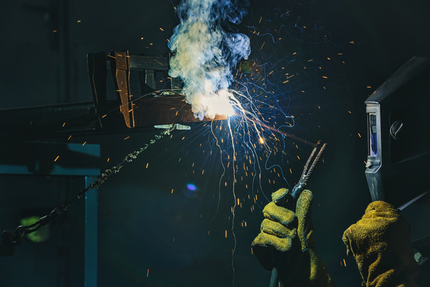 виробництво робітника зварювального металу з іскрами на заводі
  - Фото, зображення