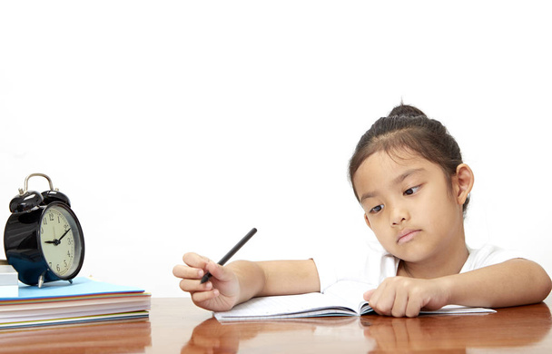 Asiatique Petite fille concentrée tout en faisant ses devoirs, Zone vide pour les lettres ensoleillées à côté de la nature le matin
 - Photo, image