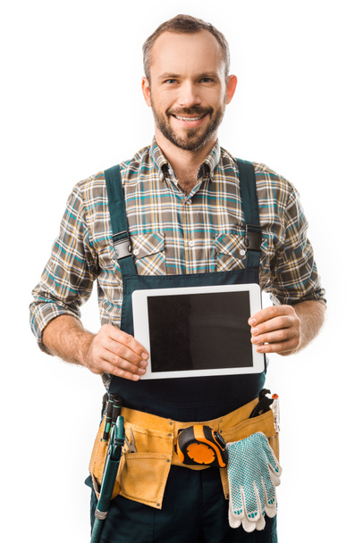 handsome smiling plumber showing tablet with blank screen isolated on white - Photo, Image