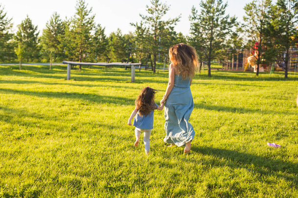 Aile ve çocuk kavramı - anne ve parkta yürüyüş ve güzel doğa kızı. - Fotoğraf, Görsel
