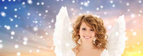 teenage girl with angel wings over snow - 写真・画像