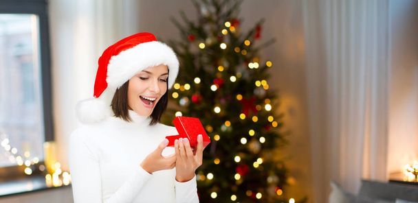 surprised woman in santa hat with christmas gift - Photo, Image