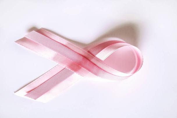 The pink colored ribbon - international symbol of breast cancer awareness and moral support for women. Isolated background, copy space, close up, top view fat lay. - Foto, afbeelding