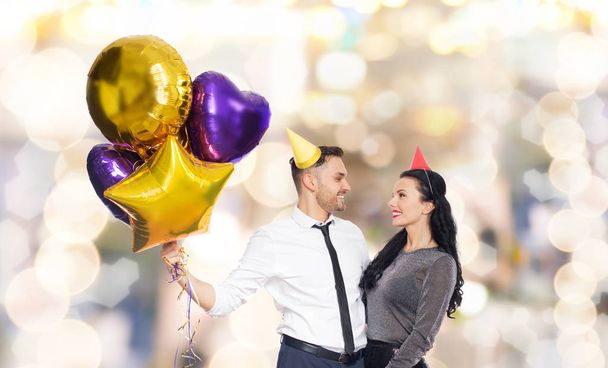happy couple with party caps and balloons - Photo, image