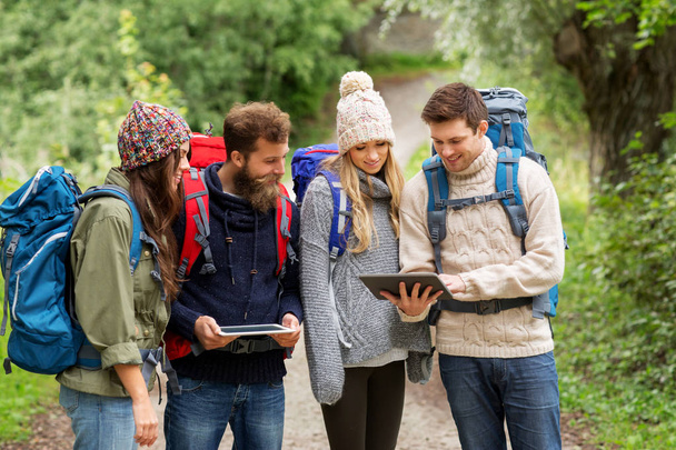 friends or travelers with backpacks and tablet pc - Foto, afbeelding