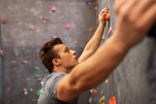young man exercising at indoor climbing gym - Foto, afbeelding