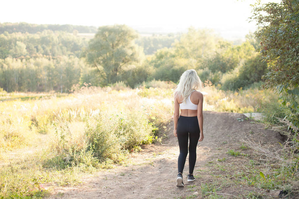 Nő-sport, fitness napsütéses dombon futás - Fotó, kép