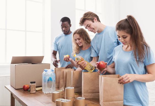 Volontaires emballant des aliments et des boissons dans des sacs en papier
 - Photo, image