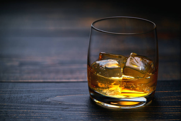 whisky z lodem na drewnianym stole na czarny drewniany stół - Zdjęcie, obraz