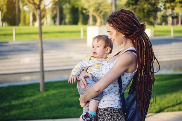 Fiatal modern boldog anya és baba fiú napos Park séta. A koncepció az öröm, az anyaság és az őszi hangulat - Fotó, kép