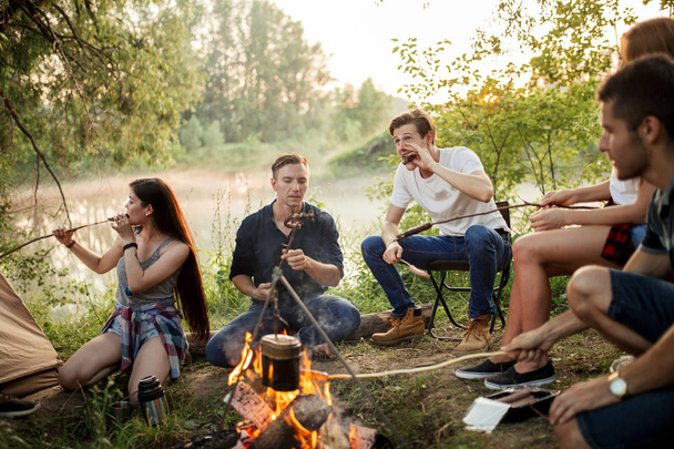 attractive hikers are eating sausages - Foto, imagen