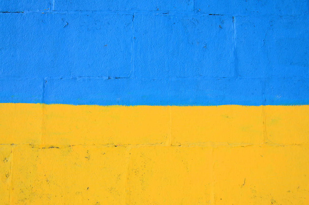 Θραύσμα από graffiti σχέδια. Το παλιό τείχος διακοσμημένα με λεκέδες χρωμάτων στο στυλ του δρόμου τέχνης του πολιτισμού. Ουκρανική σημαία. - Φωτογραφία, εικόνα