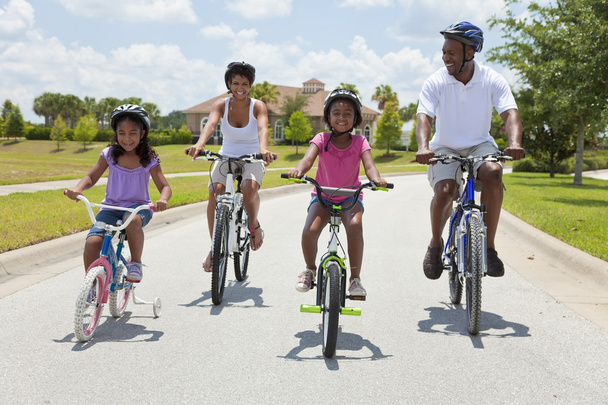 Afro-Amerikaanse familie ouders en kinderen fietsen - Foto, afbeelding