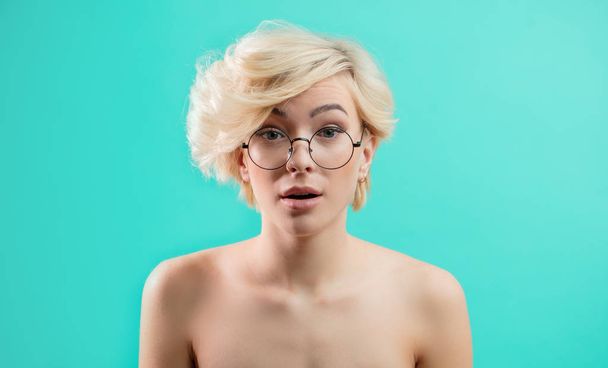 awesome blond girl in glasses looks surprised - Фото, изображение