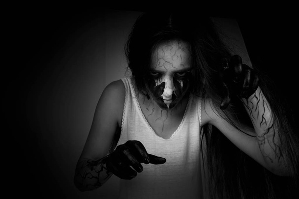 Хэллоуин. Портрет сумасшедшей девушки зомби с черными руками и венами на лице. концепция Хэллоуина и дня мертвых
. - Фото, изображение