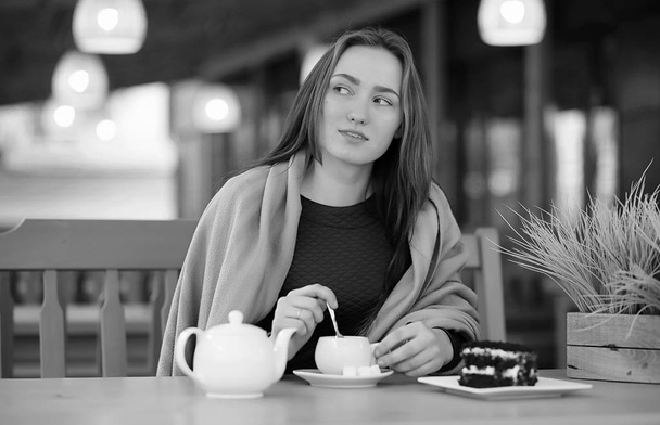 Tyttö kahvilassa istuu ja juo teetä
 - Valokuva, kuva