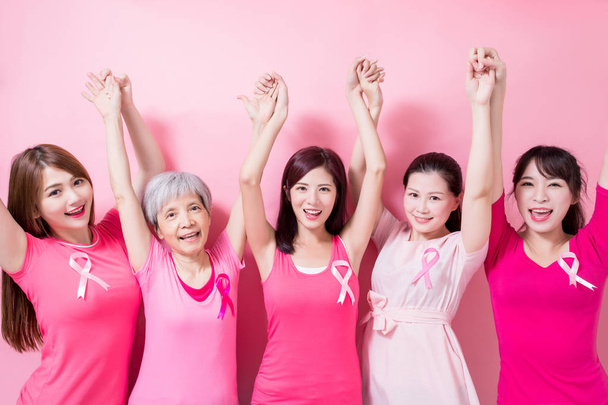 mujeres con las manos en alto. prevención del cáncer de mama en el fondo rosa
 - Foto, Imagen