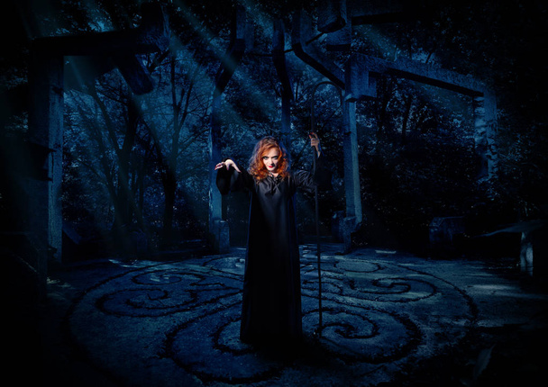 Young witch in night forest - Foto, Imagen