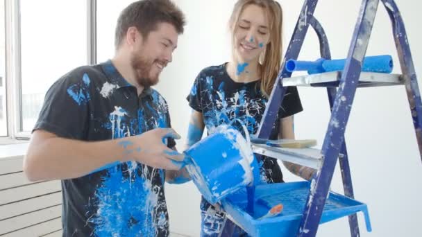 junges glückliches Paar hat Spaß beim Renovieren und Streichen seiner Wohnung - Filmmaterial, Video