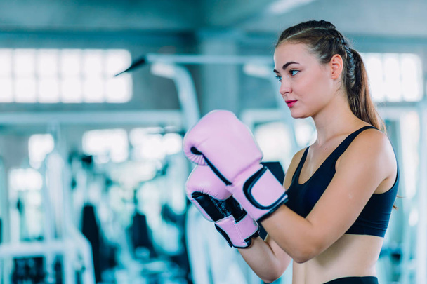 Fit beautiful woman boxer hitting a huge punching bag exercise class in a gym. Boxer woman making direct hit dynamic movement. Healthy, sports, lifestyle, Fitness, workout concept. With copy space. - Valokuva, kuva