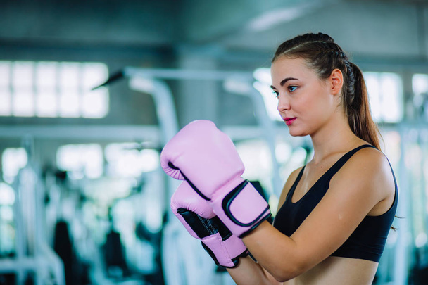Fit beautiful woman boxer hitting a huge punching bag exercise class in a gym. Boxer woman making direct hit dynamic movement. Healthy, sports, lifestyle, Fitness, workout concept. With copy space. - Photo, Image
