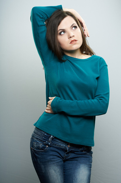 Attractive young woman in a blue shirt and jeans. Woman holds he - Photo, image
