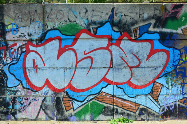 Fragment von Graffiti-Zeichnungen. die alte Wand mit Farbflecken im Stil der Street-Art-Kultur dekoriert. farbige Hintergrundtextur in warmen Tönen. - Foto, Bild