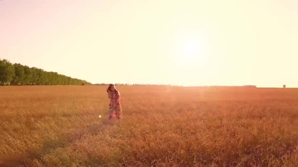 Young girl walking in wheat field - Materiał filmowy, wideo